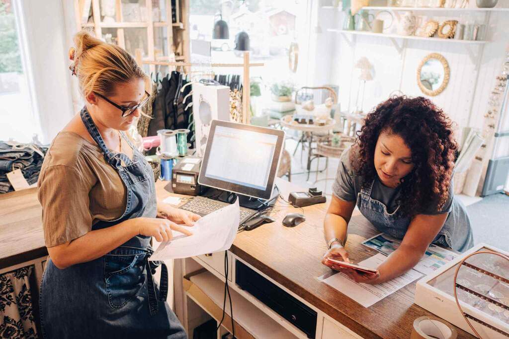 Two women collaborating at a desk in a shop